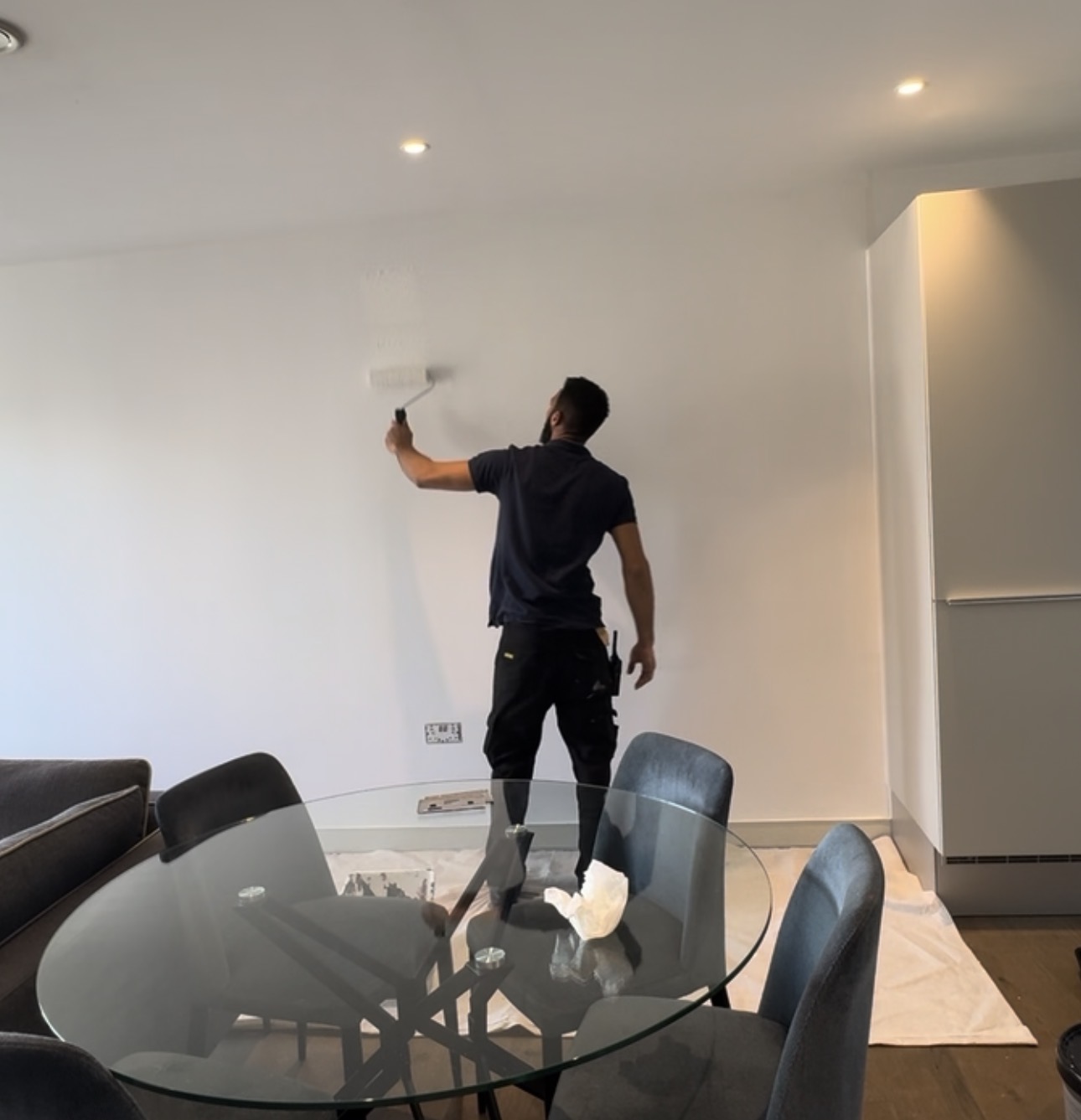 Ramos Maintenance decorator painting an interior wall with a roller